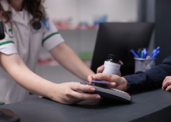 Drugstore client paying pharmaceutical treatment with credit card